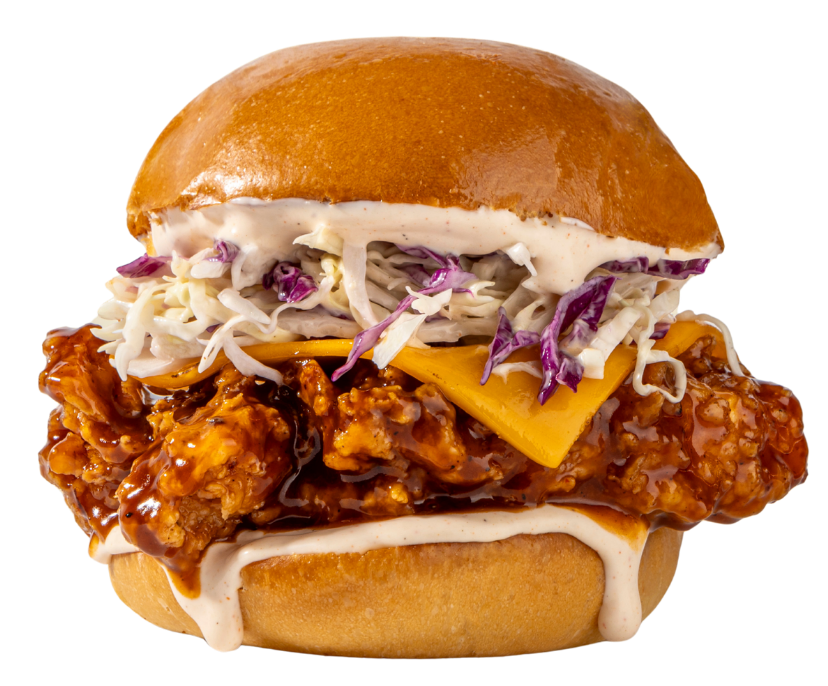 Crispy fried chicken burger with coleslaw and cheese on a brioche bun